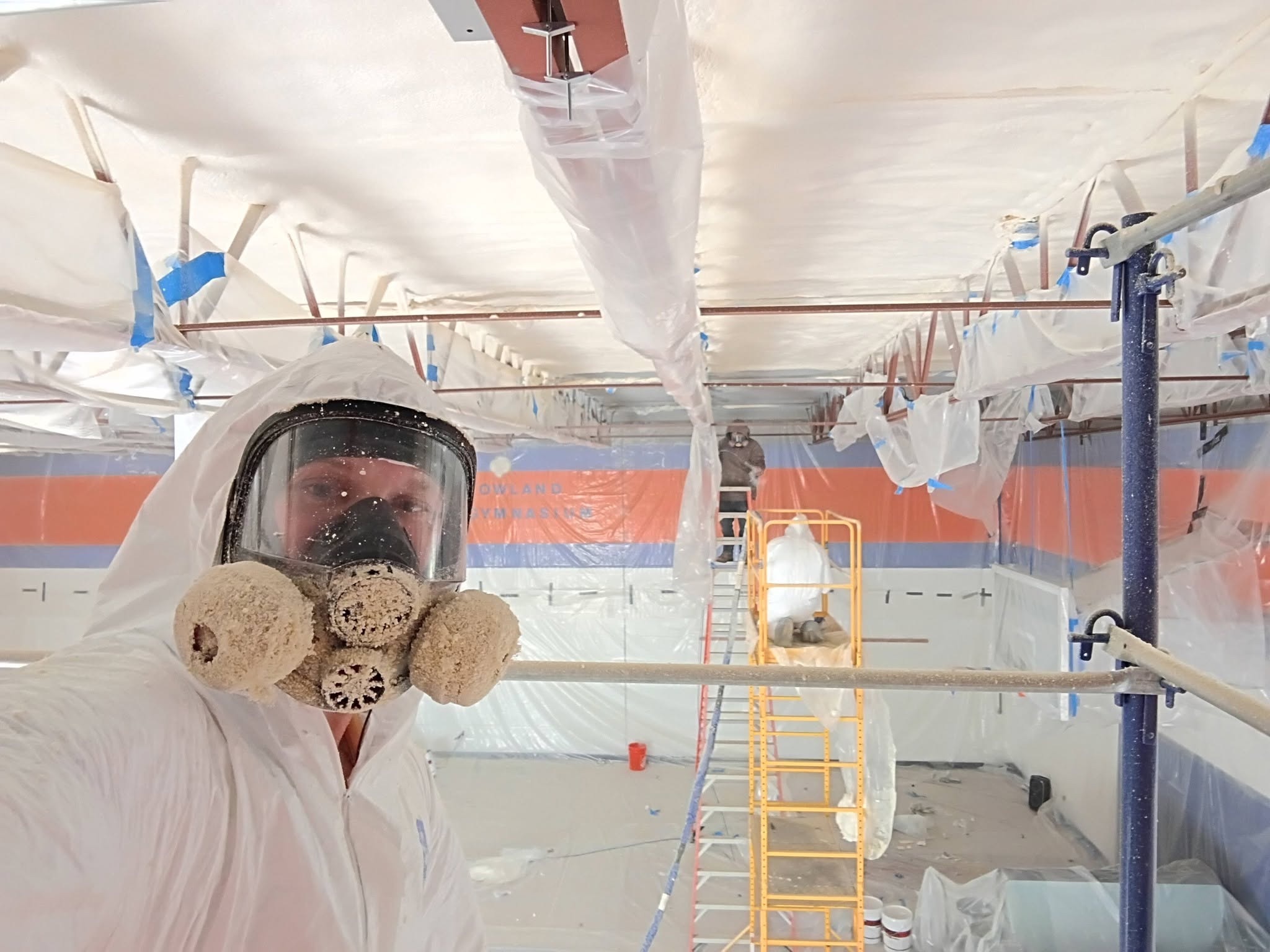 Spray foam insulation crew working inside a Nashua New Hampshire Children's Home gymnasium