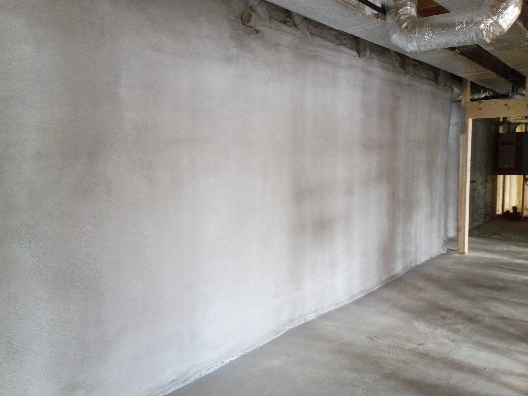 Lower-level spray foam wall insulation in a New Hampshire lakehouse