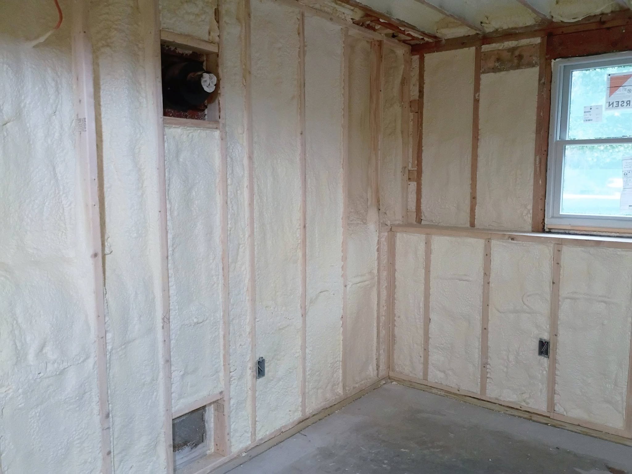 Spray foam wall insulation in a framed room corner in New Hampshire